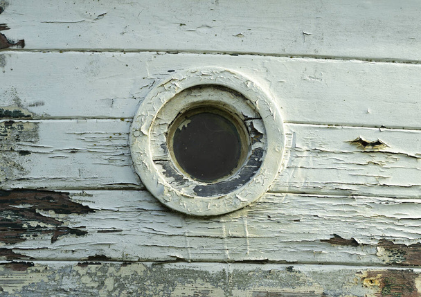 Un pequeño ojo de buey en un barco abandonado - Foto, Imagen