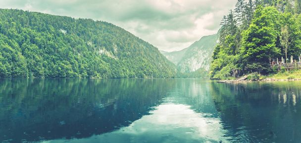 静かな湖の山の湖、朝の霧。山の範囲、国立公園、夢の自然景観、穏やかな湖の反射、周りの緑の森の目の前の山の湖のパノラマビュー、素晴らしい山のパス.  - 写真・画像