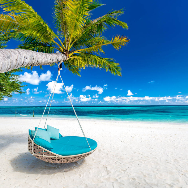 Tropical beach background as summer landscape with beach swing or hammock and white sand and calm sea for beach banner. Perfect beach scene vacation and summer holiday concept. Luxury carefree travel destination, romantic view - Photo, Image