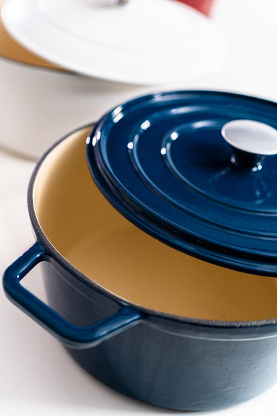 Red, white and blue enameled cast iron covered round dutch ovens on a whjite background. - Photo, Image