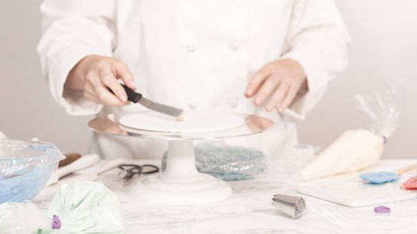 Apilar capas de pastel para crear la torta redonda de vainilla de tres capas. - Foto, imagen