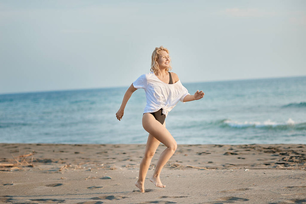 Güneş doğarken plajda koşan fitness kadın koşucusu - Fotoğraf, Görsel