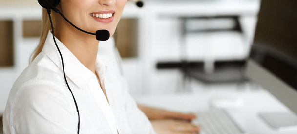 Unknown female customer service representative is consulting clients online using headset.close-up. Call center and business concept - Foto, Imagen