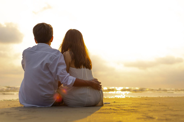 Couple in love watching sunset together on the beach travel summer holidays. People romance concept. - Foto, Bild