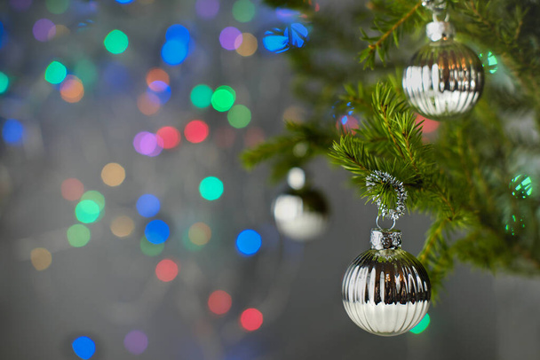 Різдвяна листівка. різдвяна ялинка прикрашена срібними кульками і барвистими боке вогнями
. - Фото, зображення