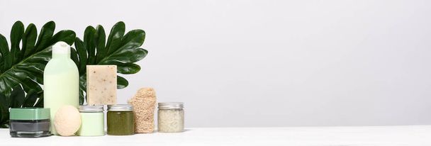 Arrangement of skin care products with palm leaves - Фото, изображение