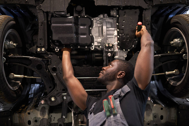 concentrated auto mechanic man repairing car hood alone - Foto, Imagem