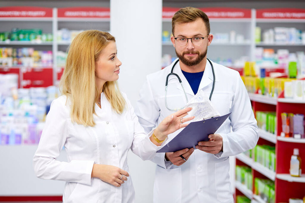 two apothecary man and woman talking, discussing medications - Photo, image