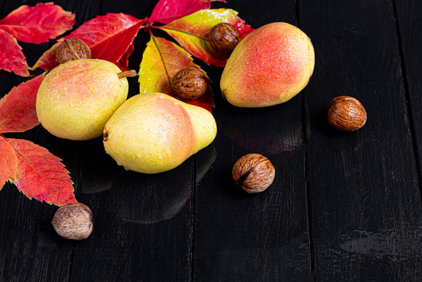 Pears on a light background. Autumn concept. Nearby are dried pear chips and nuts. Copy space. - Fotografie, Obrázek