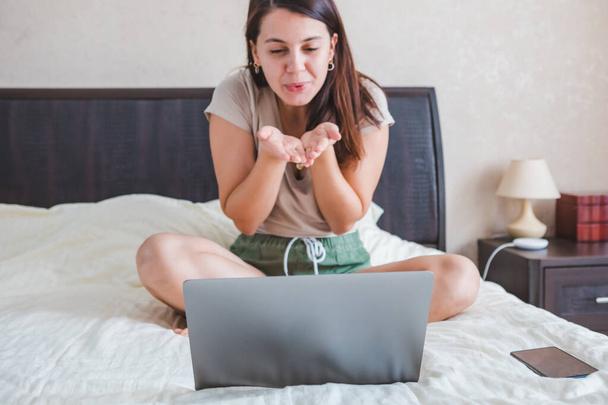 Genç ve güzel bir kadın bilgisayardan görüntülü konuşma yapıyor. Online randevu. Boşluğu kopyala - Fotoğraf, Görsel