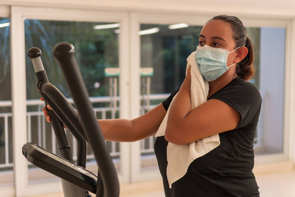 Žena s ochrannou maskou suší pot během tréninku - Fotografie, Obrázek