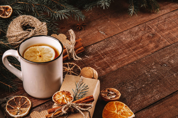  A cup of tea with lemon and eco-friendly materials for wrapping new year gifts on a wooden table, free space for text. High quality photo - Foto, Imagem
