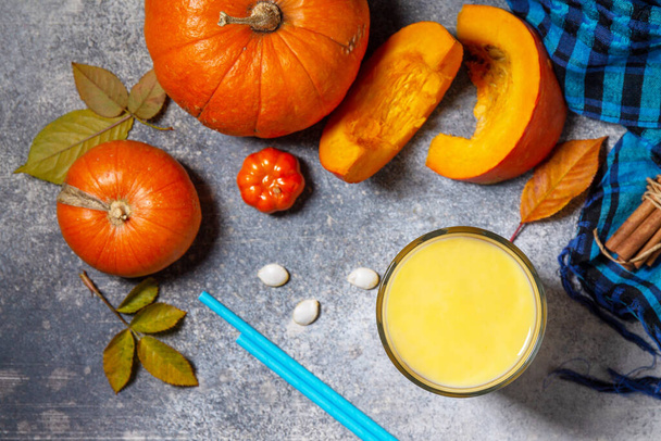 Healthy Autumn pumpkin smoothie with cinnamon in glass on a stone countertop. Top view flat lay background. - Zdjęcie, obraz