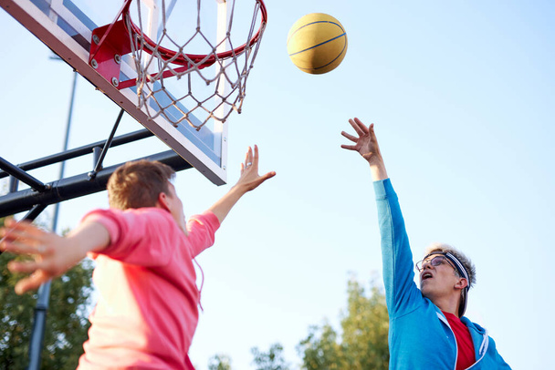 slam dunk. young basketball players throwing ball into basketball hoop at playground - Valokuva, kuva