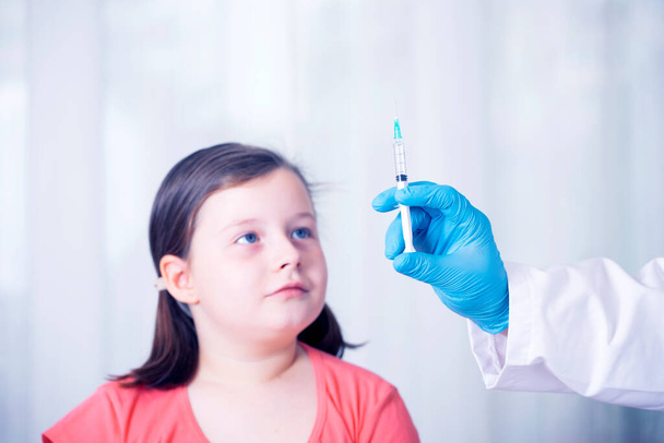 Children vaccinating immunization concept. Doctor injecting vaccination in arm of a little girl. - 写真・画像