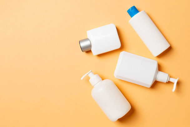Set of White Cosmetic containers isolated on colored background, top view with copy space. Group of plastic bodycare bottle containers with empty space for you design. - Photo, Image