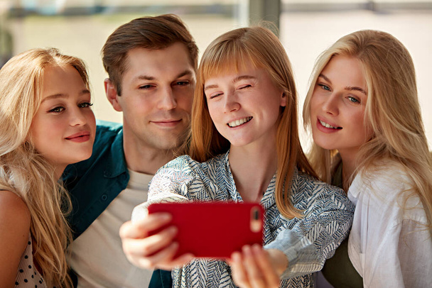 overjoyed caucasian people posing for photo in cafe together, selfie on smartphone - Fotó, kép
