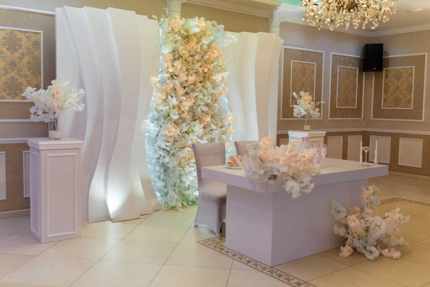Table de mariage tendre presidium décorée de fleurs, bougies, bouteilles de champagne aux couleurs pastel.  - Photo, image
