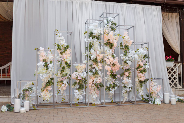 Tendre arc géométrique de mariage décoré de fleurs et de bougies aux couleurs pastel.  - Photo, image