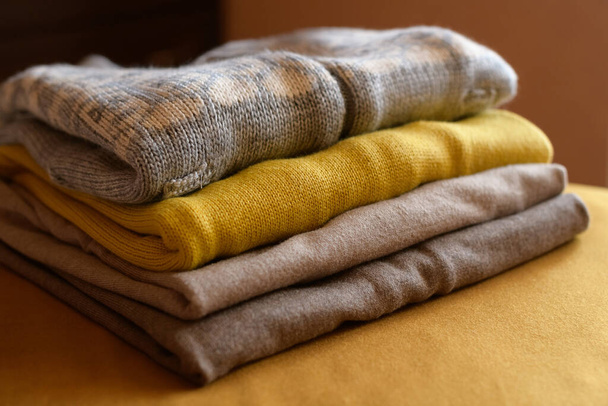 New cozy clothes for cold autumn days - sweaters and turtlenecks in gray, beige and yellow colors. - Foto, Bild