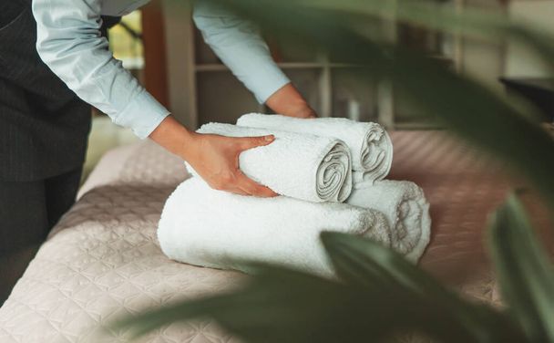 Room service. Woman changing towels in hotel room. - Foto, afbeelding