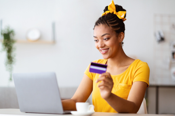 Černá žena pomocí notebooku a kreditní karty doma - Fotografie, Obrázek
