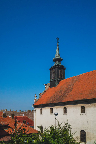 Chiesa con torre nella città di Petrovaradin sotto il cielo blu, a Novi Sad, Serbia - Foto, immagini