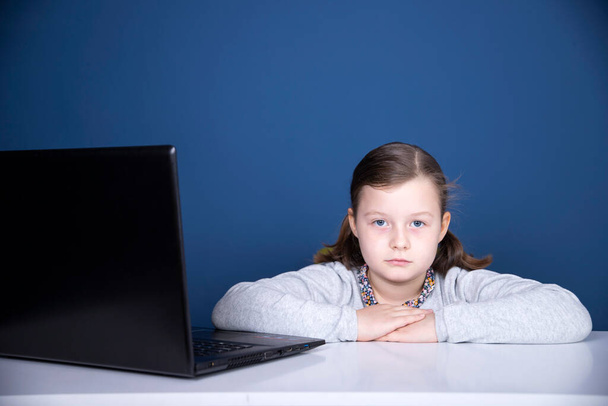Distance learning-online education. School girl watching online education classes and doing school homework. COVID-19 pandemic forces children online learning. - Photo, image