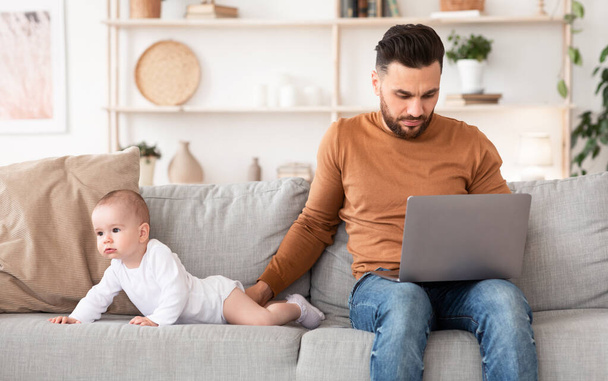 Młody ojciec z dzieckiem za pomocą laptopa przeglądania Internetu w domu - Zdjęcie, obraz