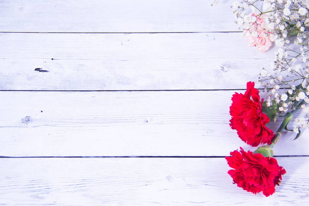 Φρέσκα ανοιξιάτικα κόκκινα λουλούδια σε μπλε βαμμένο ξύλο - Φωτογραφία, εικόνα