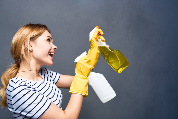 ホームケアサービスの手に洗剤と感情的なクリーニングの女性は内部グレーの背景をレンダリングします - 写真・画像