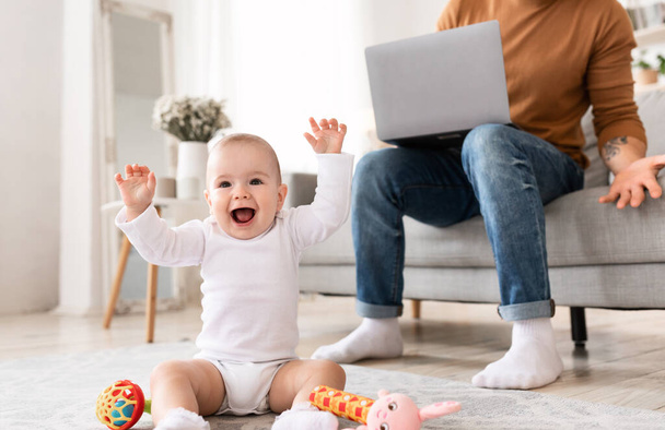 Baby peuter schreeuwen storen vader terwijl hij thuis werkt - Foto, afbeelding