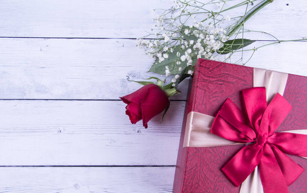 rose flower and gift box on wooden background - Foto, afbeelding