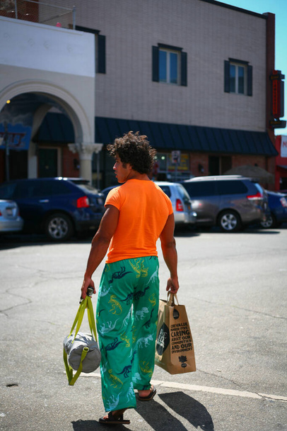 uomo con t-shirt arancione e pantaloni verdi - Foto, immagini