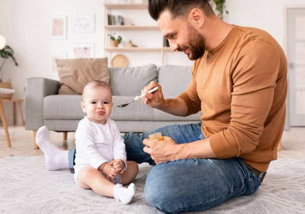 Isä lusikka ruokinta vauva isyysloman aikana kotona - Valokuva, kuva