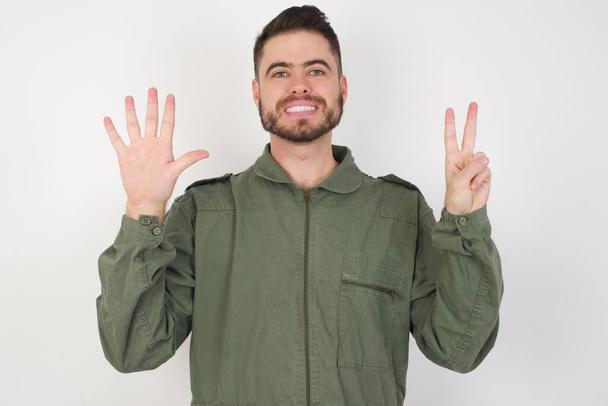 MODELO mostrando e apontando para cima com os dedos número sete, enquanto sorrindo confiante e feliz. - Foto, Imagem