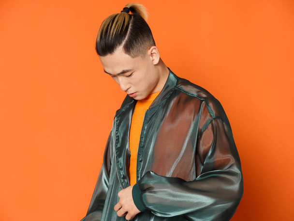 Asian man in orange t-shirt tilt his head down on isolated background - Foto, immagini