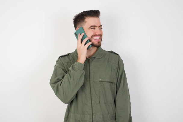 Pleasant looking happy MODEL has nice telephone conversation and looks aside, has nice mood and smiles positively while talks via cell phone - Foto, Imagem