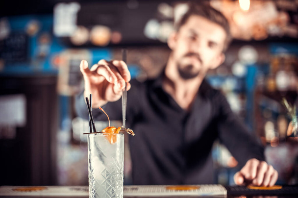 Ειδικός tapster τοποθετεί τις τελευταίες πινελιές σε ένα ποτό στο μπαρ - Φωτογραφία, εικόνα