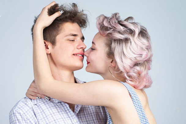 Young happy couple posing in studio.Gorgeous woman with long blond hair posing with handsome brunette man with sportive muscular man. Valentines day. Beautiful playful woman want kiss man. - Zdjęcie, obraz