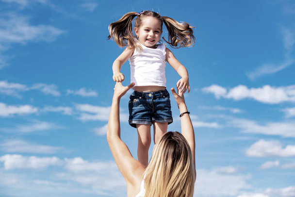 Excited girl. Happy loving family - mother and daughter. Mother and daughter on blue sky background. Happy mothers day. - Foto, Bild