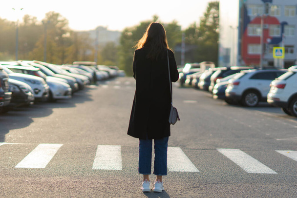 Car sharing, a young woman with a mobile phone in her hand near the Parking lot. - Фото, зображення