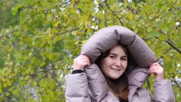 Het meisje doet een capuchon jas op haar hoofd.. - Video