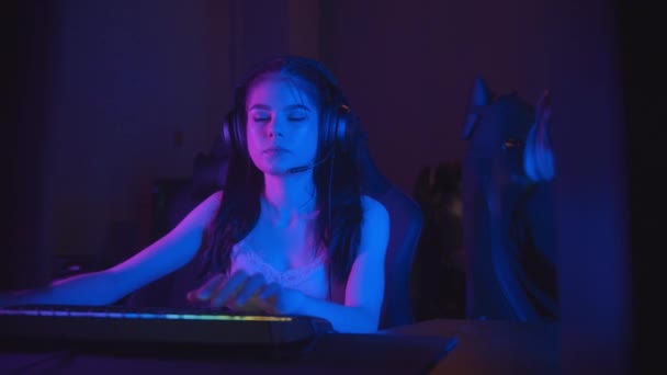 Zwei hübsche Mädchen spielen ein Online-Spiel im Neon Gaming Club - Filmmaterial, Video