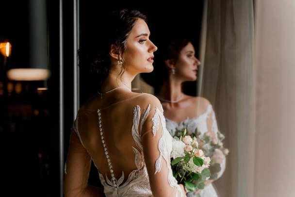 Νύφη με νυφικό φόρεμα και νυφικό πέπλο σε καφέ. Διαφήμιση για κοινωνικά δίκτυα για γραφείο γάμων και κομμωτήριο νυφικών - Φωτογραφία, εικόνα