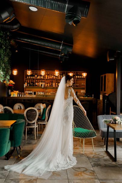 Nevěsta ve svatebních šatech a svatební závoj v kavárně. Inzerát na sociální sítě pro svatební agenturu a svatební salon - Fotografie, Obrázek