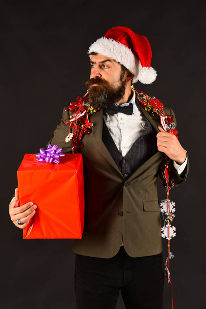 Manager with beard holds red gift. Man in smart suit - Φωτογραφία, εικόνα