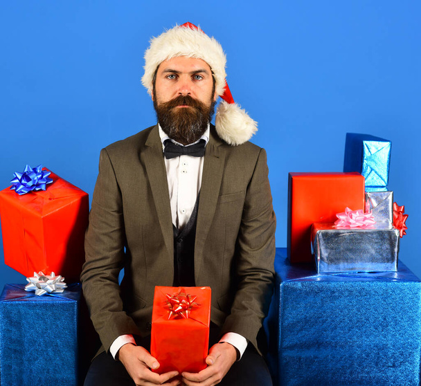 Santa in retro suit presents blue and red gifts. - Фото, изображение