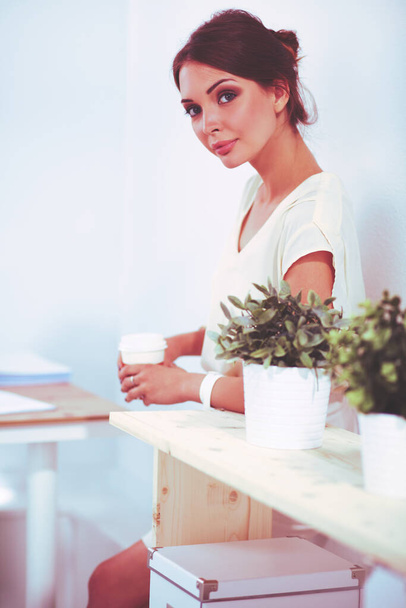 Attractive young businesswoman standing near desk in the office - Fotografie, Obrázek