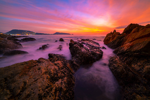 Длительное изображение экспозиции Драматический морской пейзаж с камнями на переднем плане заката или восхода солнца на фоне морских пейзажей - Фото, изображение